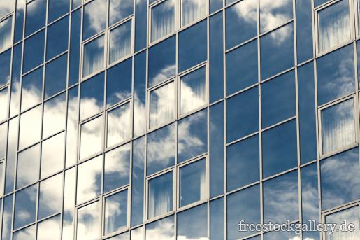 Wolke und der blaue Himmel spiegel sich in einer Glasfassade