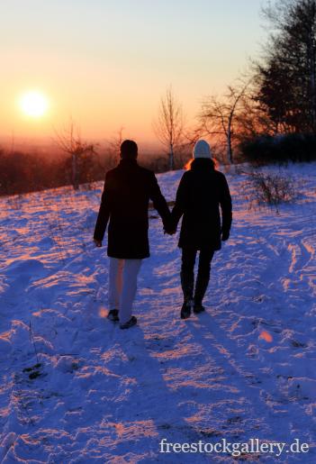 Verliebtes Paar im Schnee - Winterbild mit Sonnenuntergang