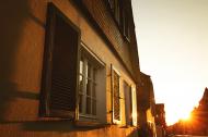 Altes Haus mit Fenstern und KlapplÃ¤den beim Sonnenutergang - Foto