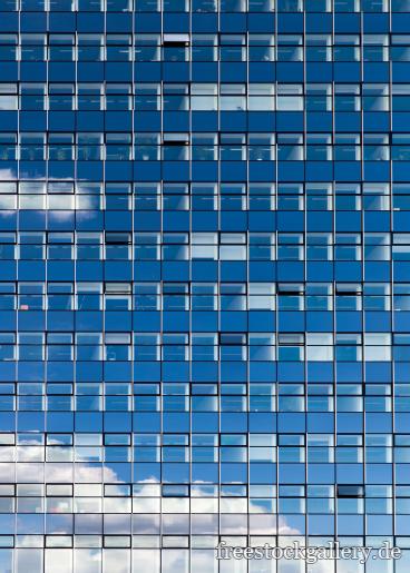 Blaue Glasfassade mit vielen Fenstern