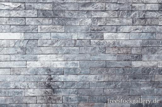 Steinmauer mit grauen kleinen Steinen - Hintergrundbild