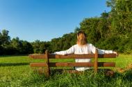 Frau sitzt auf einer Bank in der Natur - gratis Foto zum Download