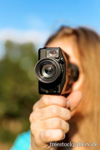 Frau filmt mit einer alten Filmkamera - Super-8-Kamera