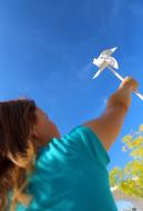 MÃ¤dchen hÃ¤lt ein Windrad in den blauen Himmel - gratis Foto