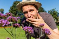 Mann riecht an Blumen - kostenlose lizenzfreie Bilder